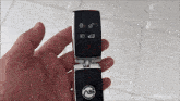 a person is holding a car key that has the letter a on the top