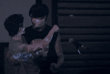 a man is carrying another man in his arms while standing in front of a microphone