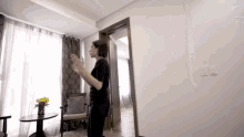 a woman is standing in a room with a table and chairs