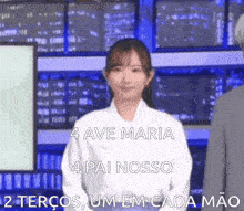 a woman in a white shirt is standing in front of a screen that says 4 ave maria 4 pai nosso 2 terços