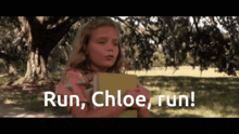 a little girl holding a book with the words run chloe run