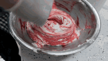 a person is mixing a red and white substance in a metal bowl that says made in animotica