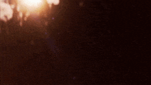 the sun is shining brightly in the dark and the rain is falling .