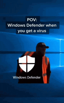 a man in a safety vest is standing in front of a windows defender logo