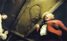 a blurry picture of a man in a red jacket standing in front of a wall