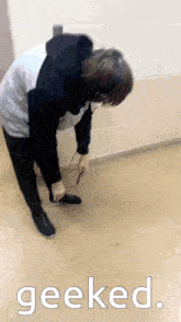 a person wearing headphones is kneeling on the floor with the word geeked above them