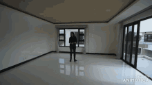 a woman is standing in an empty room with the words made in animatica on the bottom right