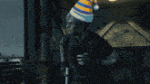 a person wearing a blue and yellow hat is standing in a dark room