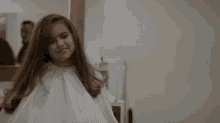 a girl giving a thumbs up while wearing a white shirt