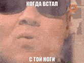 a close up of a man wearing sunglasses with a foreign language caption