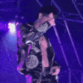 a man without a shirt is singing into a microphone on stage