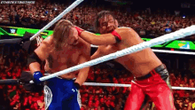 two wrestlers are fighting in a wrestling ring .