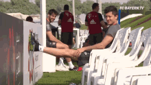 a man in a t-mobile shirt sits on a chair