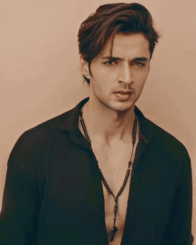 a young man wearing a denim jacket and a grey shirt