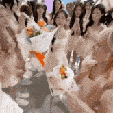 a woman holding a cake in front of a group of women