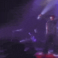 a blurry picture of a man playing a guitar on stage .