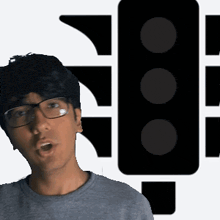 a man wearing glasses is standing in front of a black traffic light