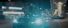 a person is driving a car down a city street at night .