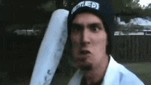 a man wearing a beanie with the word united on it is holding a baseball bat