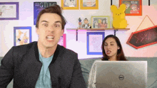a man and woman are looking at a dell laptop