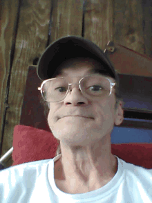 a man wearing glasses and a hat is smiling for the camera