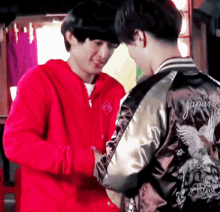 a man wearing a jacket that says japan is standing next to another man