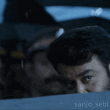 a close up of a man 's face with the name sanjo_sebi on the bottom left