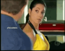 a woman in a yellow top is talking to a man in a blue shirt .