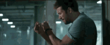 a man in a blue shirt is holding his hands together in a dark room