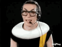 a man wearing glasses and a collar with a microphone on his head is making a funny face .