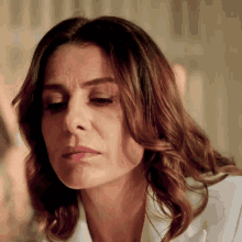 a close up of a woman 's face with a white shirt on