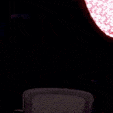 a man wearing headphones is standing in front of a microphone in a dark room .