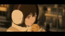 a girl wearing ear warmers is holding a piece of food in her hand