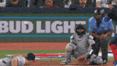 a baseball game is being played in front of a bud light ad