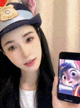 a woman wearing a police hat is holding a cell phone with a picture of judy hopps on the screen