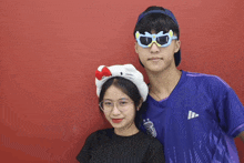 a boy and a girl are posing for a picture and the girl is wearing a hello kitty headband