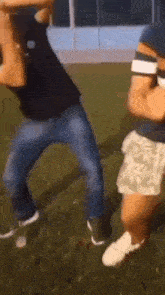 a couple of men are standing next to each other on a grassy field .