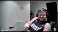 a man wearing headphones and a heat jersey is sitting on a bed .