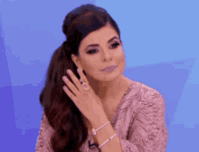a woman with a ponytail and a bracelet on her wrist