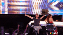 a man in a wheelchair giving a thumbs up in front of a crowd with nbc written on the bottom