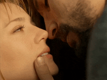 a close up of a man kissing a woman on the cheek