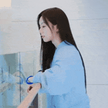 a woman in a blue robe is holding something in her hand .