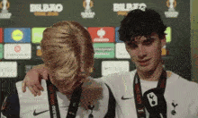 two young men are standing next to each other and one has a medal around his neck that says bilbao