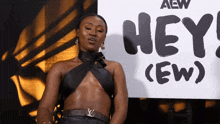 a woman is standing in front of a sign that says hey ( ew )