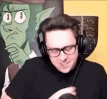 a man wearing headphones and glasses is smiling in front of a cartoon character