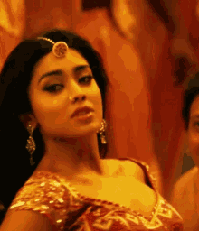 a close up of a woman 's face wearing a headpiece and earrings