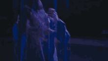 a woman with long hair is wearing a blue jacket with a hood