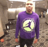 a man wearing a purple sweater with a picture of a basketball player