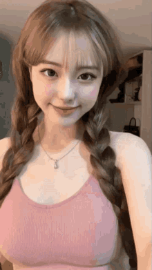 a girl with braids wearing a pink bra and a necklace