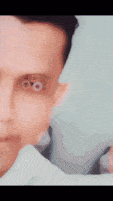 a close up of a man 's face with a tattoo on his left eye